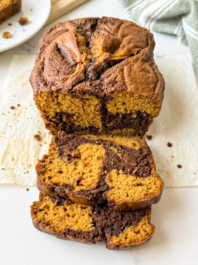 Pumpkin nutella swirl loaf sliced on parchment paper showing dark